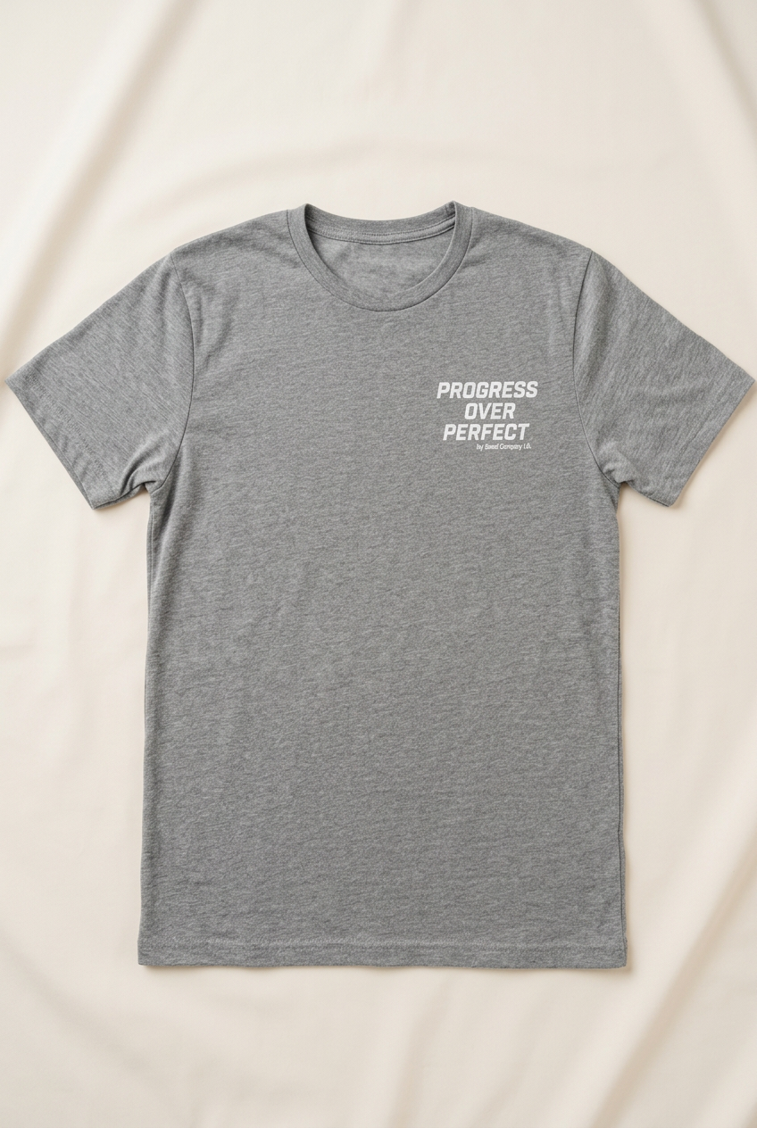 Heather-grey men's shirt with the words Progress Over Perfect in bold condensed athletic lettering on the left chest